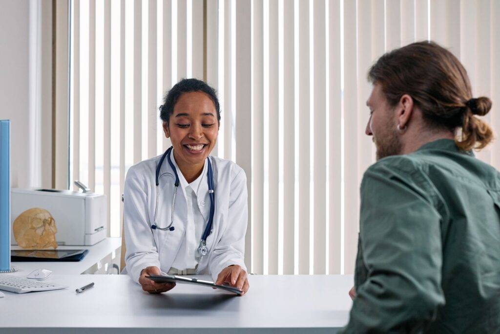 Doctor going through notes with a young patient during a GP appointment