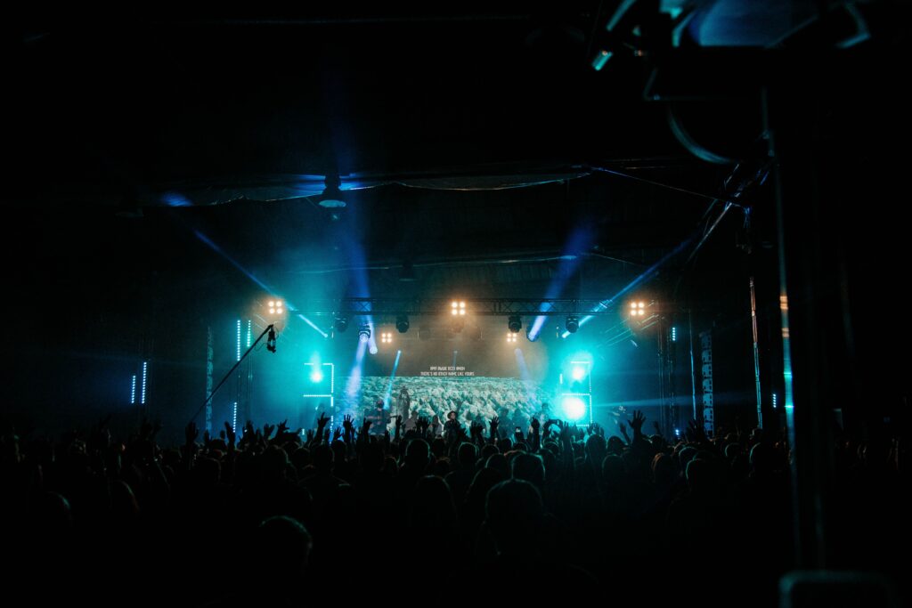 Crowd at an indoor gig with stage lights at a night event