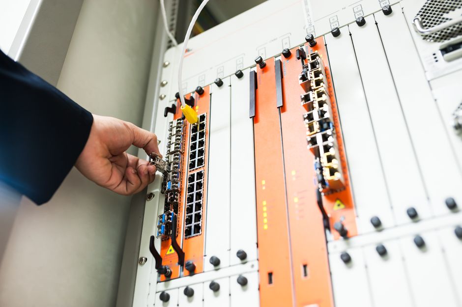 An engineer connecting broadband equipment before a student move in
