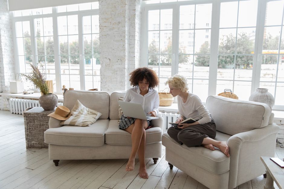 Two students in a house share using a laptop on the broadband connection
