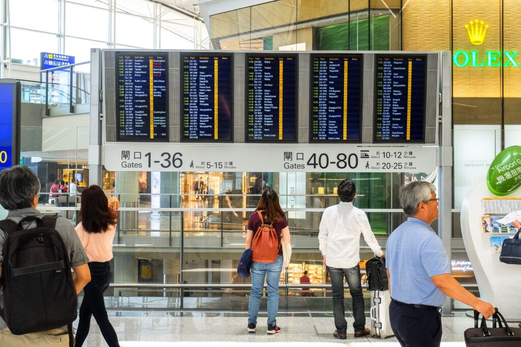 Travellers checking departure boards at Hong Kong International Airport