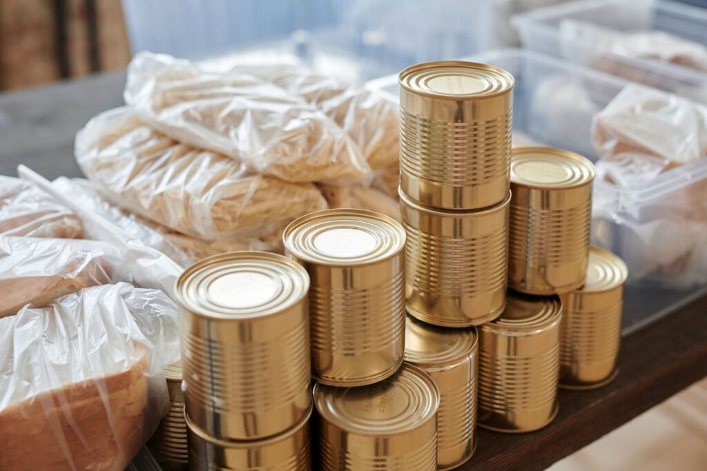 Tinned food and bagged bread set out on a table ready for a community food pantry