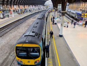 Overhead view of York train station with people on the platform and tr