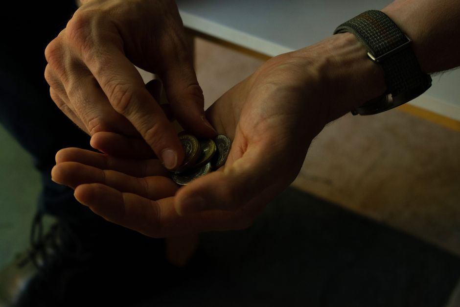 Hands counting pound coins over a table