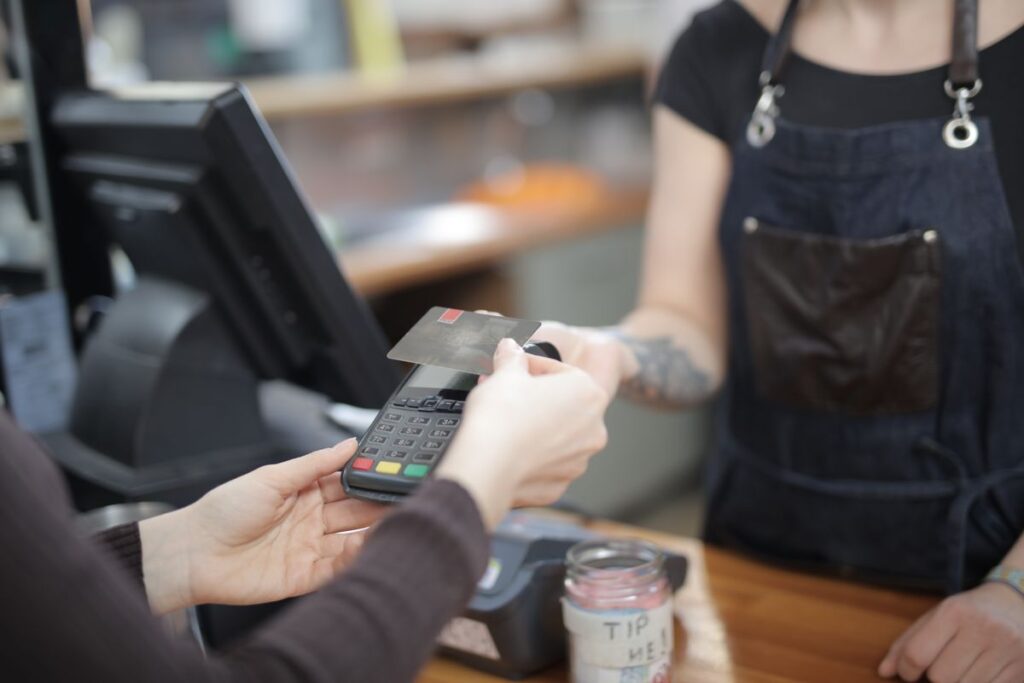 Paying with a contactless card at a shop till, where student discounts get applied