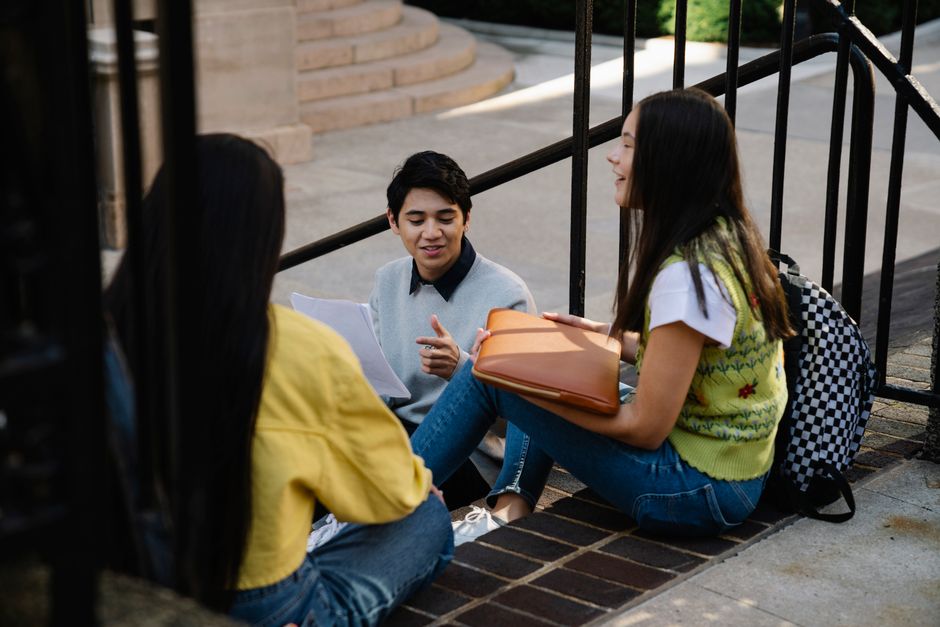 Sixth-form students sitting together outside with results papers