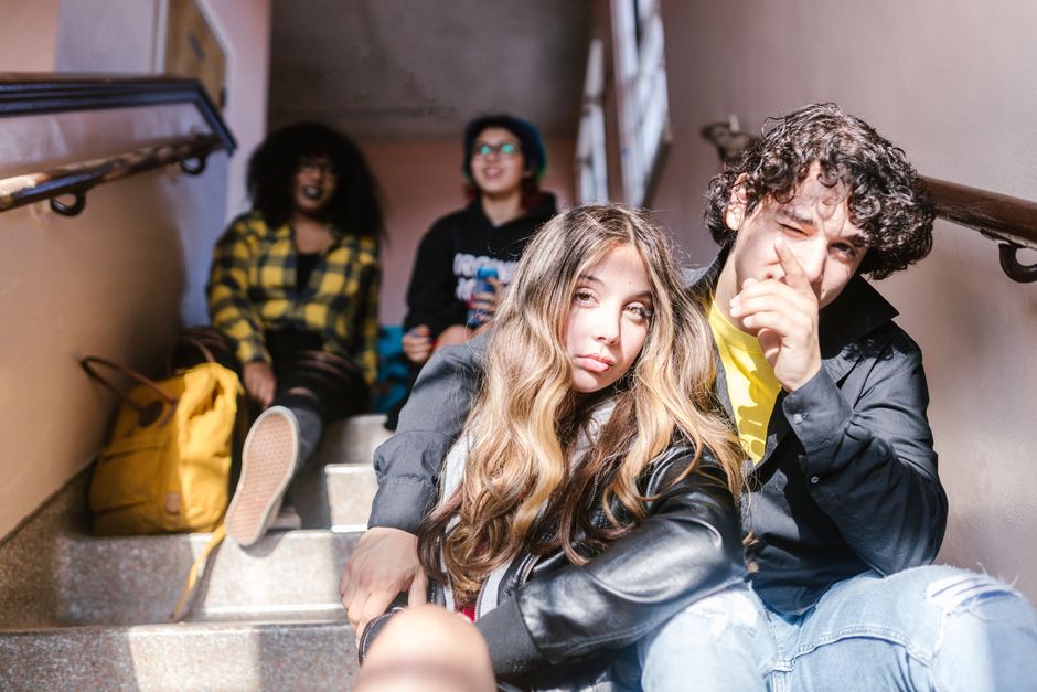 A group of teenage students sitting on school steps