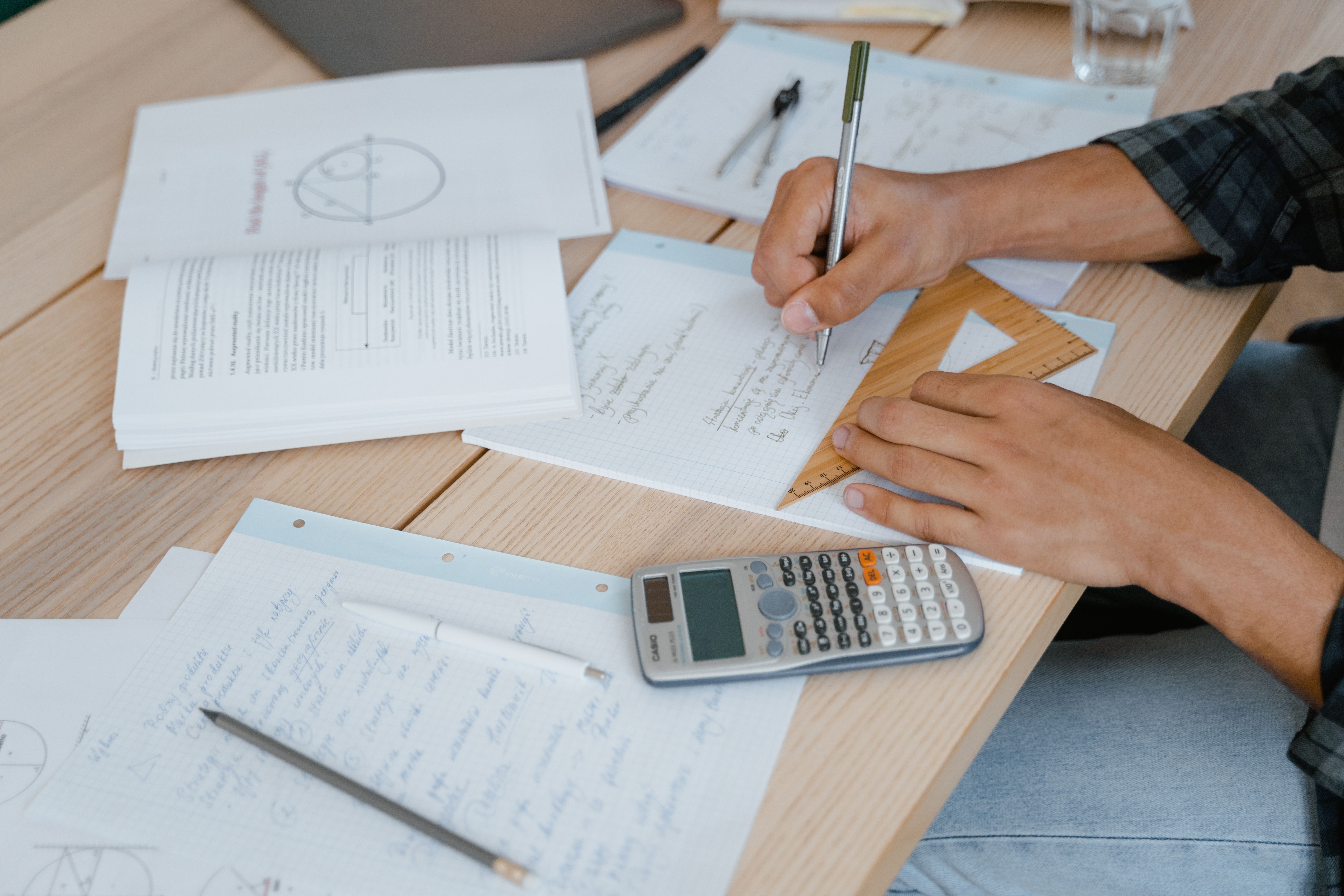 A student working through maths practice questions with a calculator