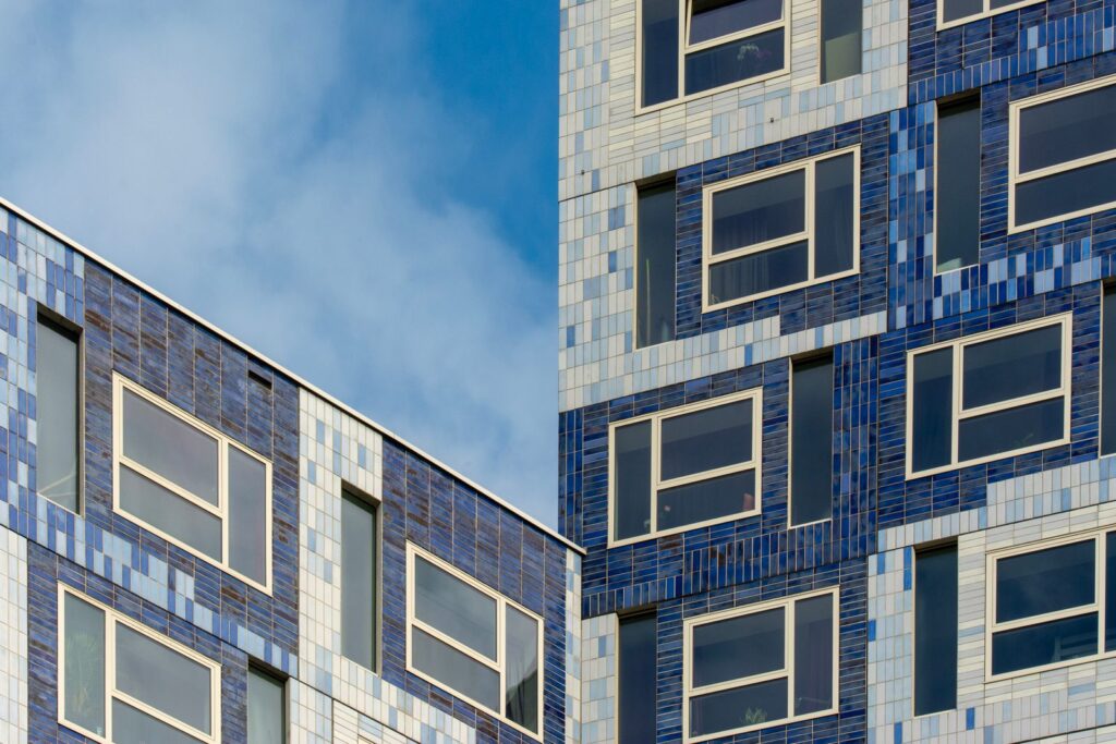 A tall modern student halls block clad in blue and white tiles, with rows of windows
