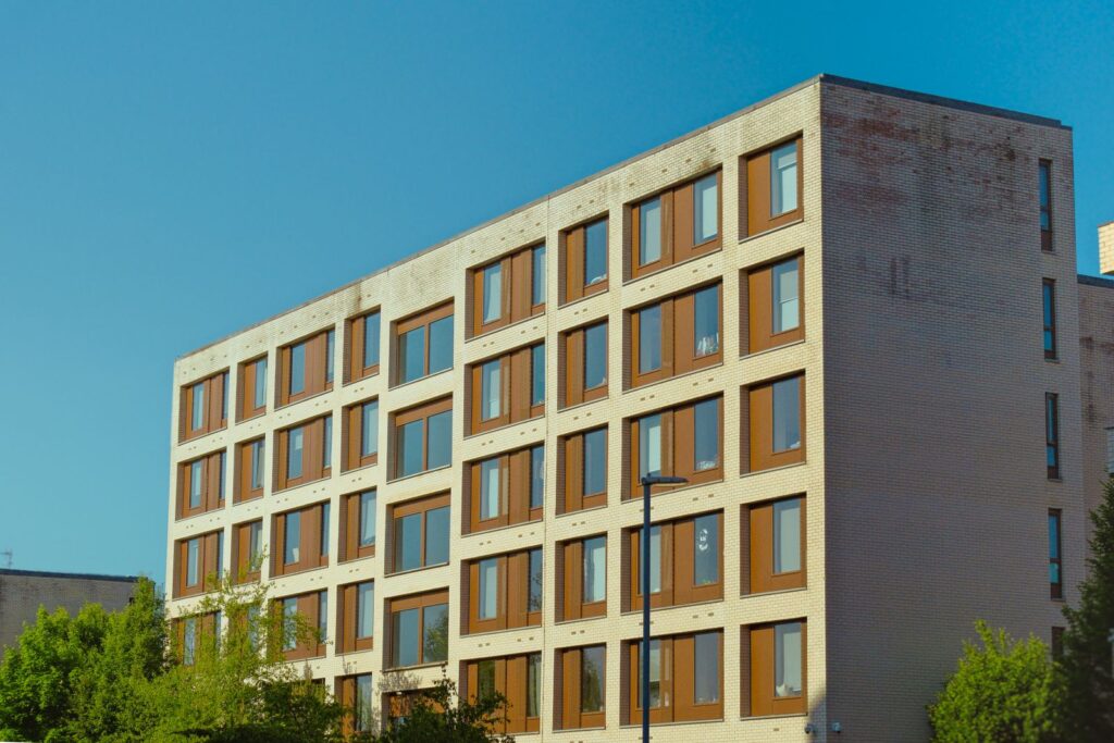A modern mid-rise purpose-built student accommodation block with cream brick and rows of identical windows